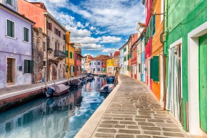 Colourful painted houses along the canal on the island of Burano, Venice, Italy. The island is a popular attraction for tourists due to its picturesque architecture